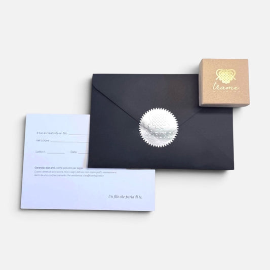 Scatolina con il logo in oro, busta nera chiusa dal sigillo argentato e card della garanzia: la confezione in cui arriva ogni gioiello — Trame gioielli