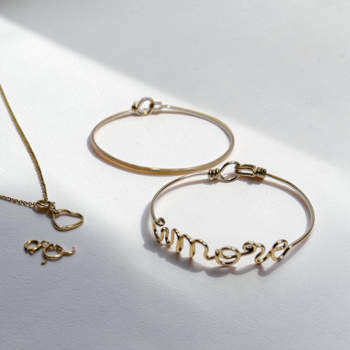 I cinque gioielli del calendario: collana Telaio Sottile con Segno Cuore e iniziale, bracciale Primo e bracciale Tratto con scritto amore