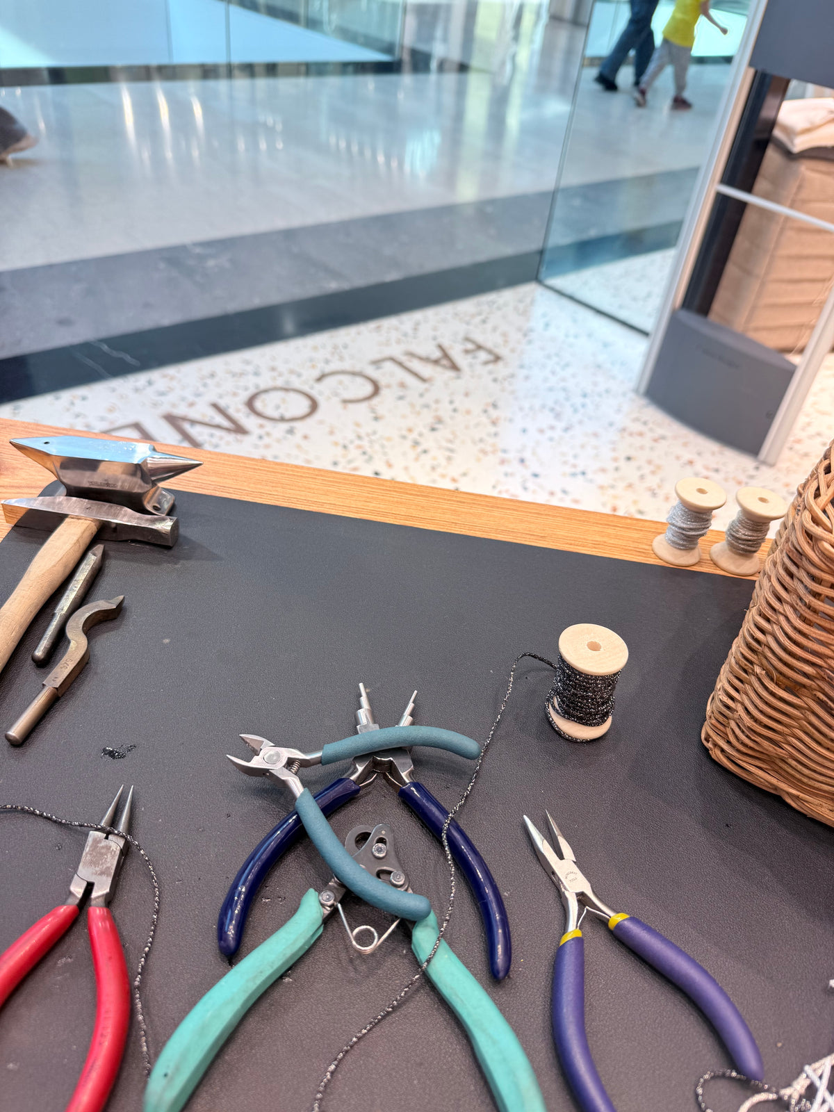 Il banco del Banchetto in uno store Falconeri: incudine, pinze e rocchetti di filo.